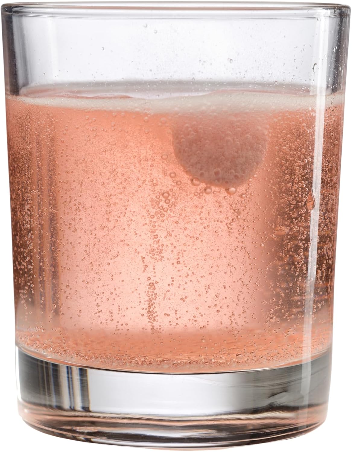 Close-up of a VitalFactors tablet dissolving in a glass of water, releasing a soft pink sparkling drink